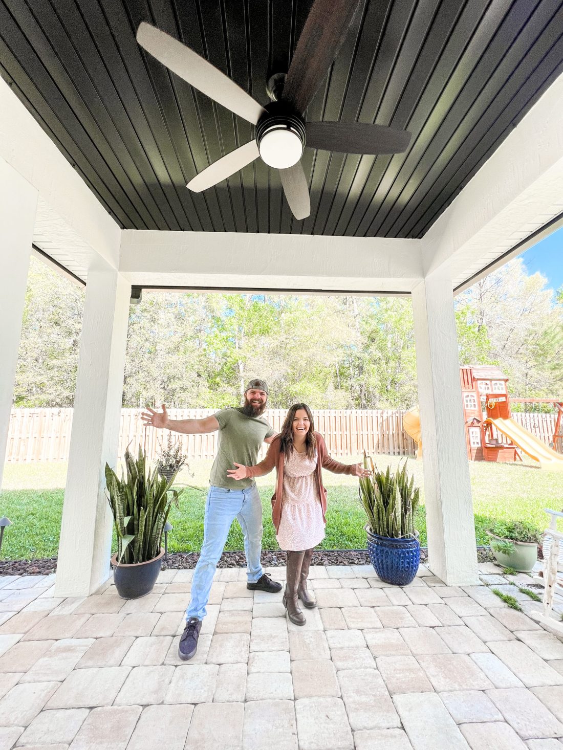 Couple standing outside with black ceiling and fan